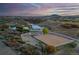 Aerial view of horse property with fencing, barn, riding arena, and lush landscape at sunset at 810 N Perry Park Rd, Sedalia, CO 80135