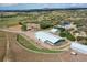 Expansive aerial view showcasing the horse property with barn, riding area, and surrounding landscape at 810 N Perry Park Rd, Sedalia, CO 80135