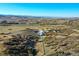 Aerial view of horse property with a barn, riding arena, and home on a sprawling landscape at 810 N Perry Park Rd, Sedalia, CO 80135