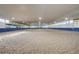 Large indoor horse riding arena with sand floor and white metal roofing at 810 N Perry Park Rd, Sedalia, CO 80135