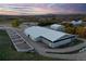 Aerial view of a large horse barn and fenced paddocks on a beautiful rural property at dusk at 810 N Perry Park Rd, Sedalia, CO 80135