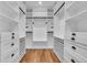 Walk-in closet with wooden floor, built-in shelves, drawers and hanging rods at 810 N Perry Park Rd, Sedalia, CO 80135