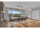 Elegant dining area with a modern light fixture, stone fireplace, and scenic views from large windows at 810 N Perry Park Rd, Sedalia, CO 80135