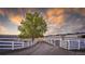 Horse property showing riding runs and an expansive dirt driveway under a dramatic sky at 810 N Perry Park Rd, Sedalia, CO 80135