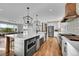 Bright kitchen features a large island with a sink, stainless steel appliances, and wood flooring at 810 N Perry Park Rd, Sedalia, CO 80135