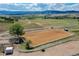 Aerial view of horse riding arena with white fencing, surrounded by picturesque scenery at 810 N Perry Park Rd, Sedalia, CO 80135