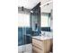 Stylish bathroom featuring a modern vanity, blue tiled shower with glass doors, and contemporary fixtures at 2525 S Meade St, Denver, CO 80219