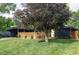 Well-maintained home with a lush lawn, mature trees, modern facade, and a covered parking area at 2525 S Meade St, Denver, CO 80219