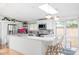 Bright kitchen with stainless steel appliances, skylight, island with breakfast bar, and access to an outdoor space at 2525 S Meade St, Denver, CO 80219