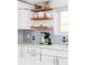 Kitchen corner with floating shelves, tiled backsplash, coffee maker, and sink at 2525 S Meade St, Denver, CO 80219
