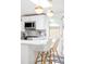 Bright kitchen with stainless steel appliances, breakfast bar, and gold pendant lighting at 2525 S Meade St, Denver, CO 80219
