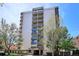 Exterior shot of a high-rise condo building with balconies and mature shade trees at 1223 Race St # 605, Denver, CO 80206