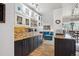 Open-concept kitchen with granite counters, mosaic tile backsplash, custom cabinetry, and access to the living room at 1223 Race St # 605, Denver, CO 80206