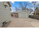 Detached single car garage with a carport extension and a large driveway at 1100 S Quitman St, Denver, CO 80219