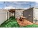 Backyard with artificial turf and a brick patio under a covered area at 1925 S Irving St, Denver, CO 80219