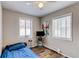 Cozy bedroom featuring wood-look flooring, a ceiling fan, and two windows at 1925 S Irving St, Denver, CO 80219