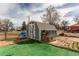 Detached garage features double doors, a gray exterior, shingled roof, and a brick walkway at 1925 S Irving St, Denver, CO 80219