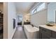 Elegant bathroom featuring a soaking tub, sleek vanity with dual sinks, and ample natural light at 21261 E 60Th Ave, Aurora, CO 80019