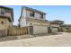 Exterior shot of townhome showing private garage and fencing with a stone and siding facade at 21261 E 60Th Ave, Aurora, CO 80019