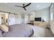 Spacious primary bedroom featuring a ceiling fan, walk-in closet, and comfortable king-size bed at 21261 E 60Th Ave, Aurora, CO 80019