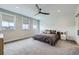 Bright primary bedroom with a large bed, modern ceiling fan, and ample natural light from large windows at 21261 E 60Th Ave, Aurora, CO 80019