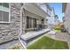 Covered patio with stone accents, artificial turf, and sliding glass doors for indoor-outdoor living at 21261 E 60Th Ave, Aurora, CO 80019
