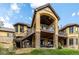 Back exterior view of home featuring multiple decks and balconies with stone and stucco accents at 648 Ruby Trust Dr, Castle Rock, CO 80108