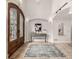 Elegant foyer with travertine floors, console table, and decorative wrought iron and glass entry door at 648 Ruby Trust Dr, Castle Rock, CO 80108