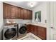 Modern laundry room with stainless steel washer and dryer, ample cabinet space, and a sink at 648 Ruby Trust Dr, Castle Rock, CO 80108