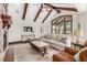 Inviting living room featuring wood beams, comfortable sofa, and large windows at 648 Ruby Trust Dr, Castle Rock, CO 80108