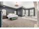 A spacious main bedroom features a tray ceiling, a chandelier, and large windows with shutters at 648 Ruby Trust Dr, Castle Rock, CO 80108