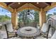 Covered patio boasts an ornate table and seating, with wooded views at 648 Ruby Trust Dr, Castle Rock, CO 80108