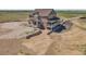 Wide aerial view of a two-story home featuring a covered porch and a spacious yard at 49346 E County Road 6, Bennett, CO 80102