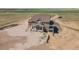 Aerial view of a two-story home with covered porches surrounded by a sprawling landscape at 49346 E County Road 6, Bennett, CO 80102