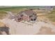 High aerial view of two-story home with covered porches and extensive acreage at 49346 E County Road 6, Bennett, CO 80102