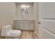 Well-lit powder bathroom with modern vanity, fixtures, and wood flooring at 49346 E County Road 6, Bennett, CO 80102