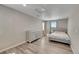 Spacious bedroom with laminate flooring, large window, and dresser with silver accents at 49346 E County Road 6, Bennett, CO 80102