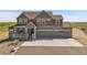 Charming two-story home features a covered porch, three-car garage, and stone accents at 49346 E County Road 6, Bennett, CO 80102