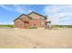 Exterior view of a two-story home, showcasing a covered porch and spacious outdoor area at 49346 E County Road 6, Bennett, CO 80102