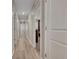 Well-lit hallway with hardwood-style flooring and neutral paint at 49346 E County Road 6, Bennett, CO 80102