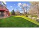 Spacious backyard features a well-manicured lawn, a deck, and a charming wooden fence at 10915 Acadia Ln, Parker, CO 80138