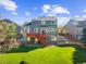 Expansive backyard featuring lush green lawn, a red wooden deck with stairs, and a well-maintained exterior at 10915 Acadia Ln, Parker, CO 80138