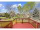Backyard view featuring a wood deck with a white rail fence, mature trees, and green space at 10915 Acadia Ln, Parker, CO 80138
