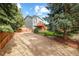 View of the backyard and parking area, featuring mature trees and fencing at 10915 Acadia Ln, Parker, CO 80138