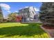 A large, well-maintained backyard with green grass, a raised deck, and beautiful landscaping at 10915 Acadia Ln, Parker, CO 80138