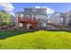 Backyard with lush green lawn, a red wood deck, and mature trees surrounding the property at 10915 Acadia Ln, Parker, CO 80138