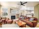 Spacious living room with fireplace, ceiling fan, and seamless flow to the kitchen and dining area at 10915 Acadia Ln, Parker, CO 80138