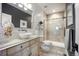 Modern bathroom with a vessel sink, decorative accents, and glass shower with tan and white tiles at 20243 High Pines Dr, Monument, CO 80132