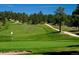 Scenic golf course view with lush green fairways, mature trees, and a sand bunker in the foreground at 20243 High Pines Dr, Monument, CO 80132