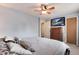 Bedroom features a ceiling fan, a TV on a dresser, and neutral walls at 12104 Ivanhoe Ct, Brighton, CO 80602
